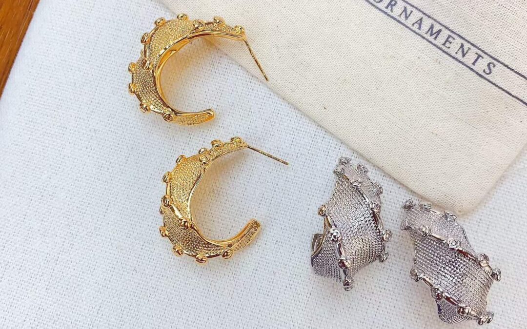 Gold and silver anti-tarnish hoop and stud earrings on linen