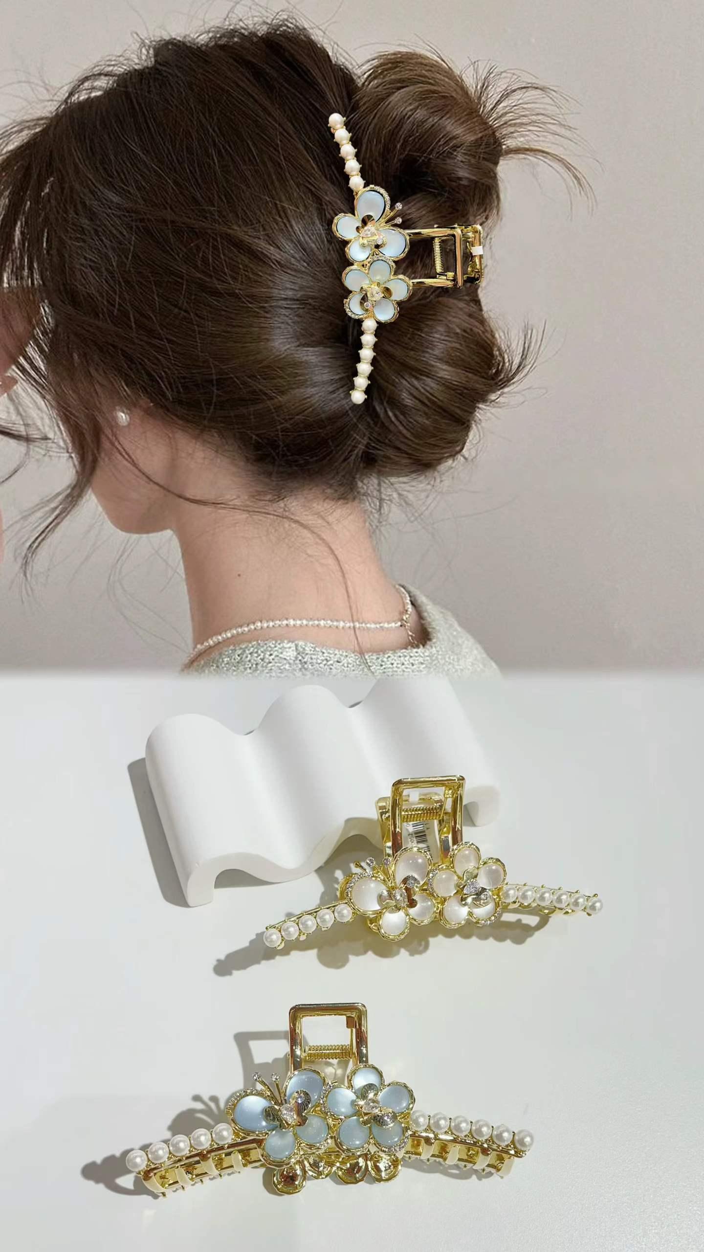 Pearl and floral claw clip holding an elegant low bun updo