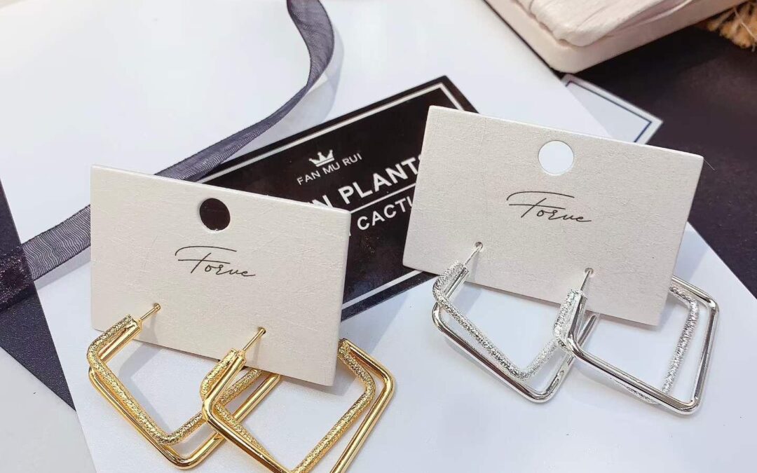 Gold and silver hoop earrings with a gift box and ribbon for Raksha Bandhan